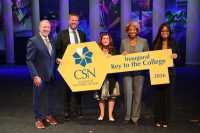 Five individuals on stage hold a large yellow key-shaped sign for the College of Southern Nevada's inaugural 2026 Key to the College.